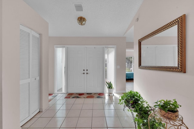 tiled foyer entrance featuring a textured ceiling