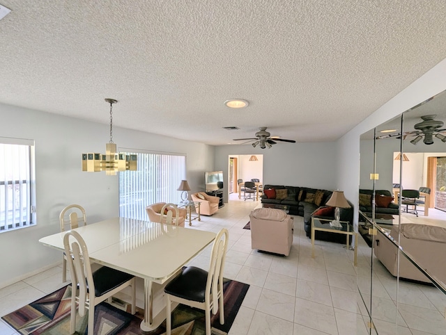 dining space featuring ceiling fan with notable chandelier, light tile patterned floors, and a textured ceiling