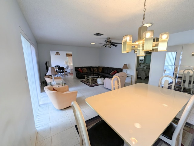 tiled dining space featuring ceiling fan and a textured ceiling