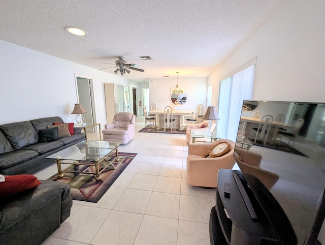 living room featuring a wealth of natural light, ceiling fan, light tile patterned floors, and a textured ceiling