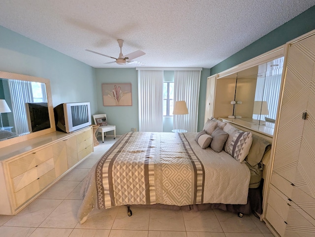 bedroom with light tile patterned floors, a textured ceiling, and ceiling fan