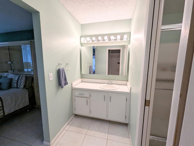 bathroom featuring vanity, a textured ceiling, a shower with shower door, and tile patterned flooring