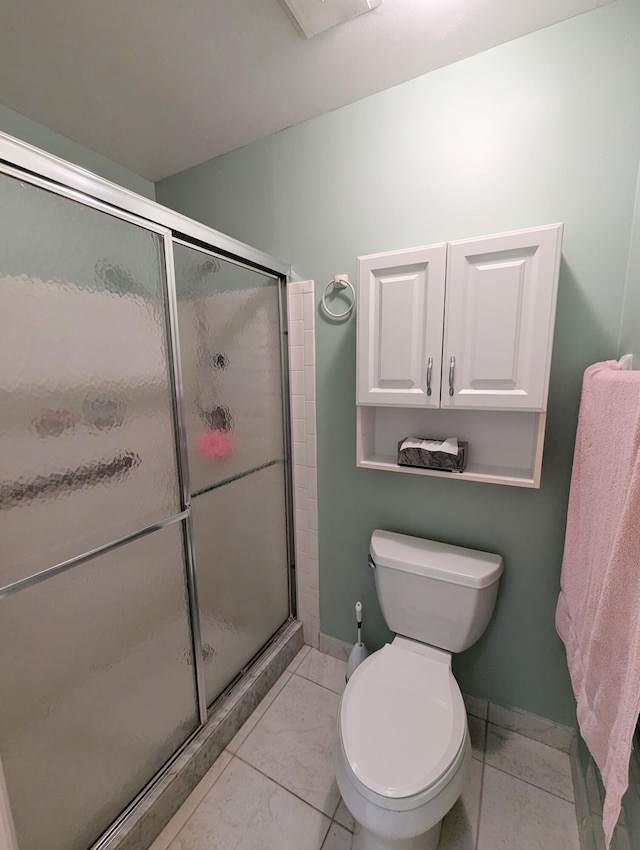 bathroom featuring tile patterned floors, toilet, and walk in shower