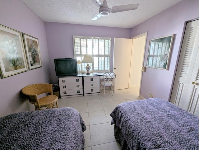 bedroom featuring light tile patterned floors, a textured ceiling, and ceiling fan