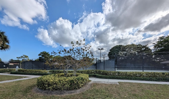 view of home's community with a yard and tennis court