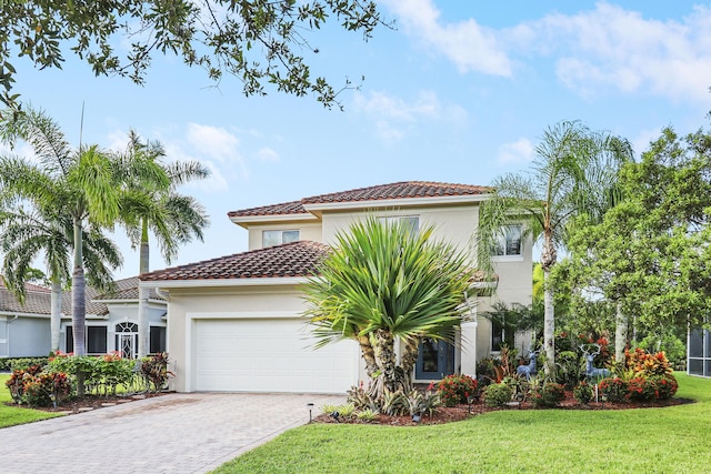 mediterranean / spanish home with a garage and a front lawn