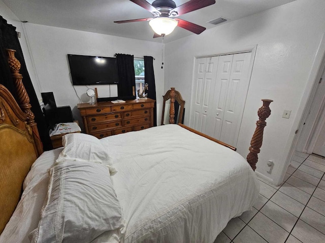 tiled bedroom with ceiling fan and a closet