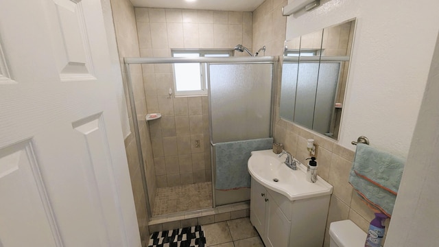 bathroom with vanity, tile patterned floors, toilet, and walk in shower