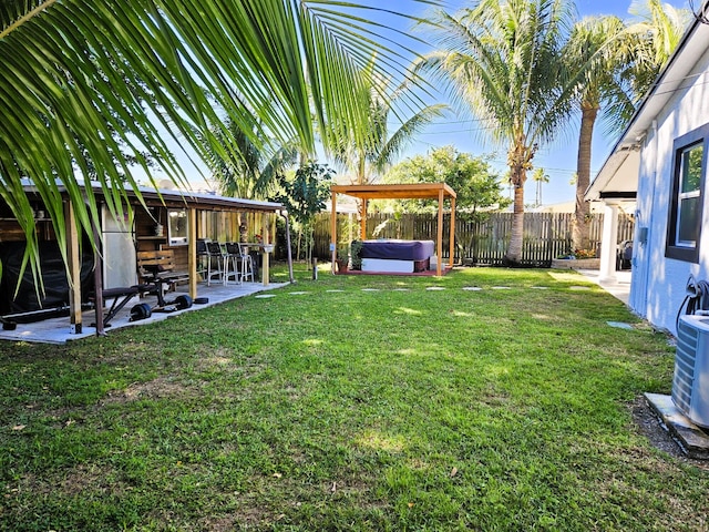 view of yard featuring central AC unit, a hot tub, and a patio