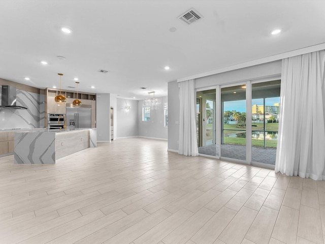 unfurnished living room featuring a notable chandelier