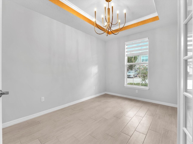 unfurnished room featuring a raised ceiling, an inviting chandelier, and ornamental molding