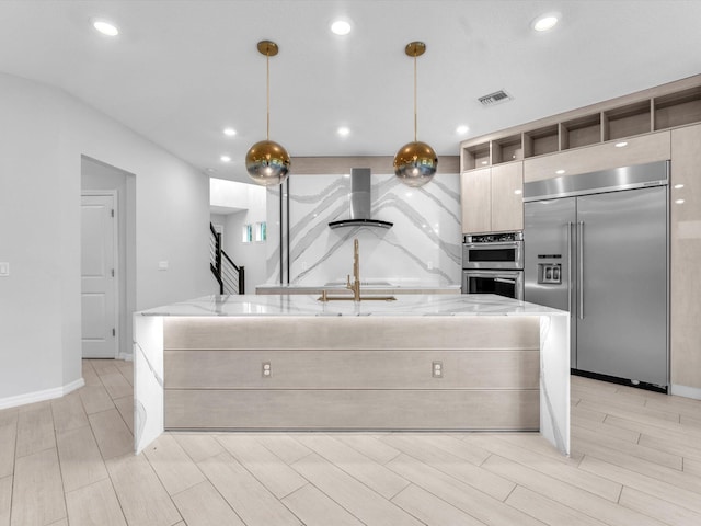 kitchen with exhaust hood, a center island with sink, hanging light fixtures, stainless steel appliances, and light stone counters