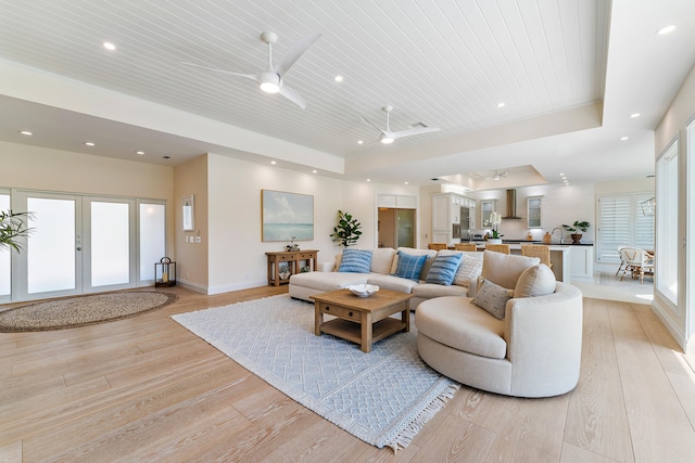 living room with a wealth of natural light, french doors, light hardwood / wood-style floors, ceiling fan, and wooden ceiling