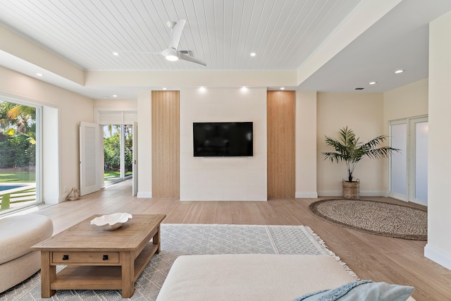 living room with wooden ceiling, hardwood / wood-style floors, ceiling fan, and a tray ceiling