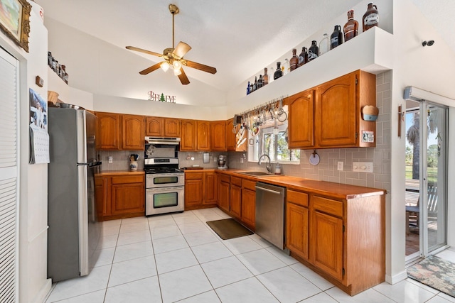 12354 Golden Eagle St, Port Saint Lucie, FL 34987 - kitchen featuring appliances with stainless steel finishes, under cabinet range hood, ceiling fan, brown cabinets, and vaulted ceiling