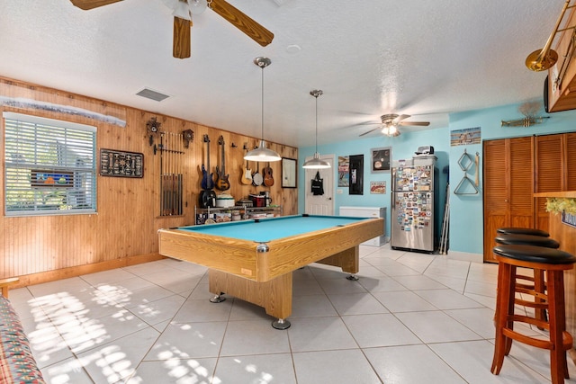 playroom with billiards, wooden walls, ceiling fan, light tile patterned floors, and a textured ceiling