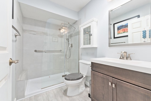 bathroom with vanity, hardwood / wood-style flooring, toilet, and a shower with door