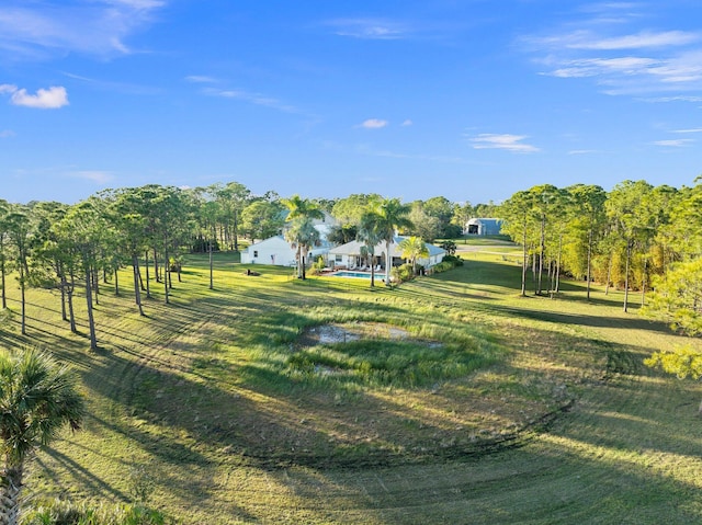 view of property's community with a rural view and a lawn