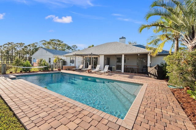 view of pool featuring a patio area and a sunroom