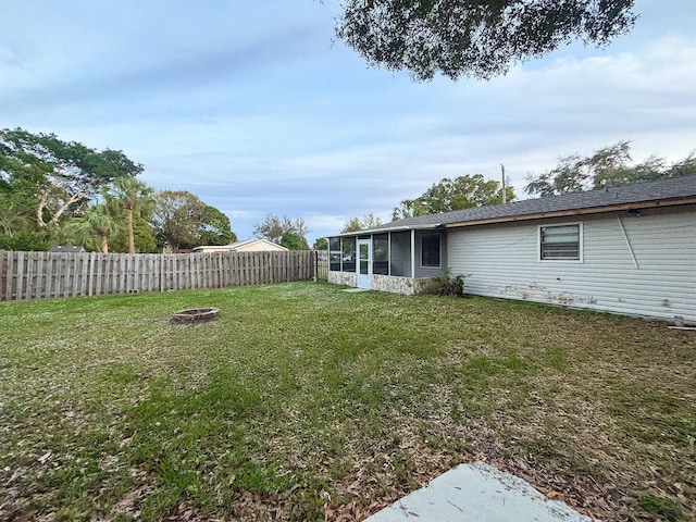 view of yard with a sunroom and an outdoor fire pit