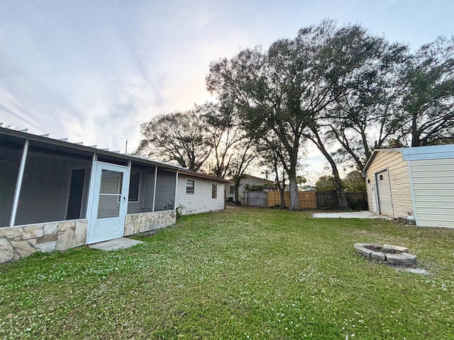 yard at dusk with a fire pit and an outdoor structure