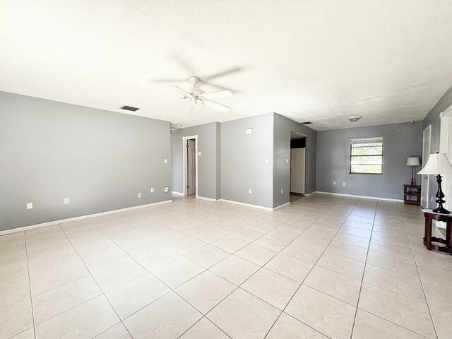 unfurnished living room with light tile patterned floors, a textured ceiling, and ceiling fan