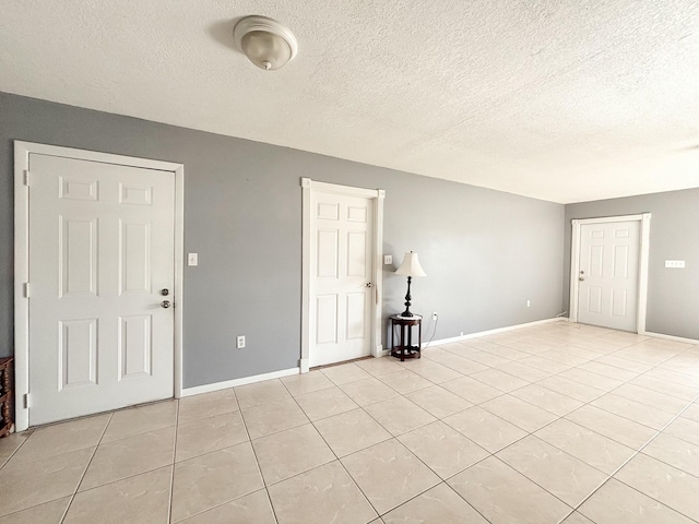 unfurnished room featuring light tile patterned floors and a textured ceiling