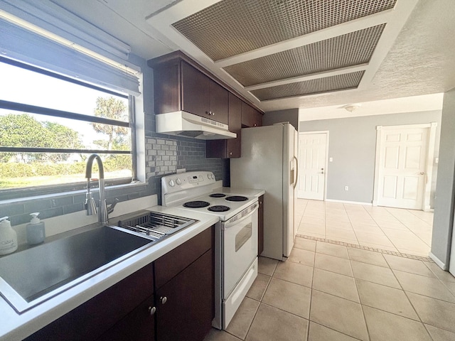 kitchen with white appliances, sink, tasteful backsplash, light tile patterned flooring, and dark brown cabinetry