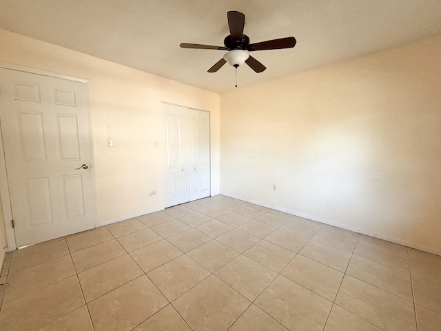 unfurnished bedroom featuring ceiling fan, light tile patterned floors, and a closet