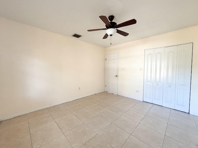 unfurnished bedroom with ceiling fan, light tile patterned flooring, and a closet