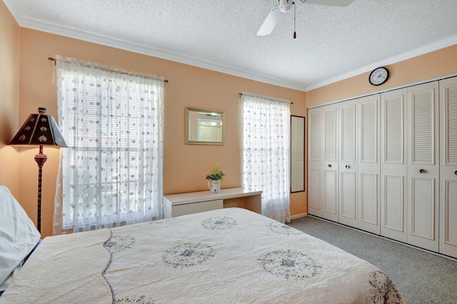 carpeted bedroom with ornamental molding, a textured ceiling, ceiling fan, and a closet