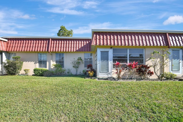 rear view of house featuring a yard