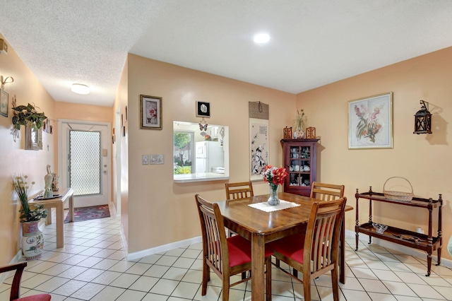 dining area featuring a textured ceiling and light tile patterned flooring