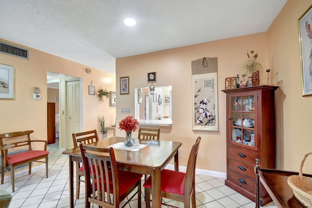 dining room with a textured ceiling and light tile patterned floors