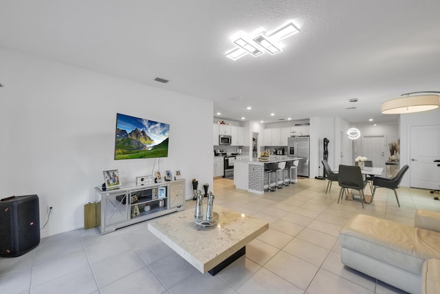 living room with light tile patterned flooring and a textured ceiling