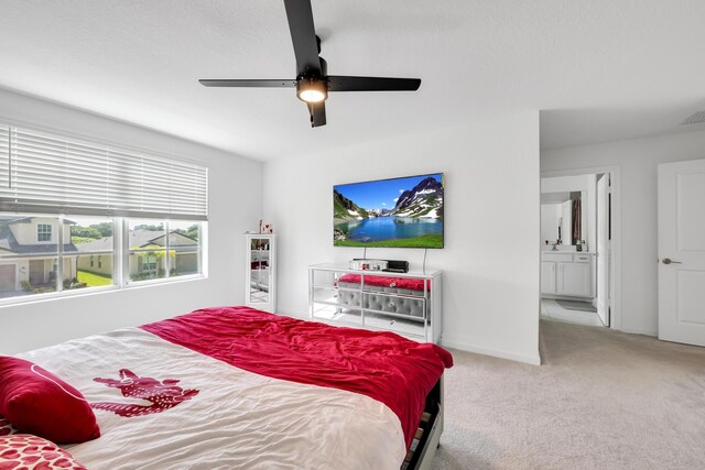 carpeted bedroom with ceiling fan and ensuite bathroom