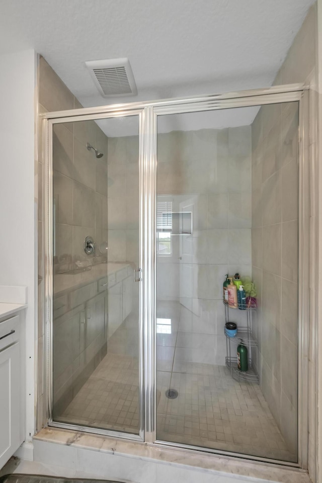 bathroom with a shower with door and vanity