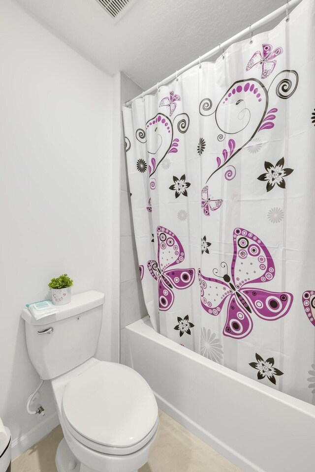 bathroom with shower / tub combo and toilet