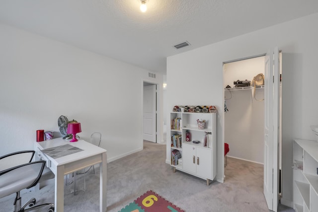 office with a textured ceiling and light carpet