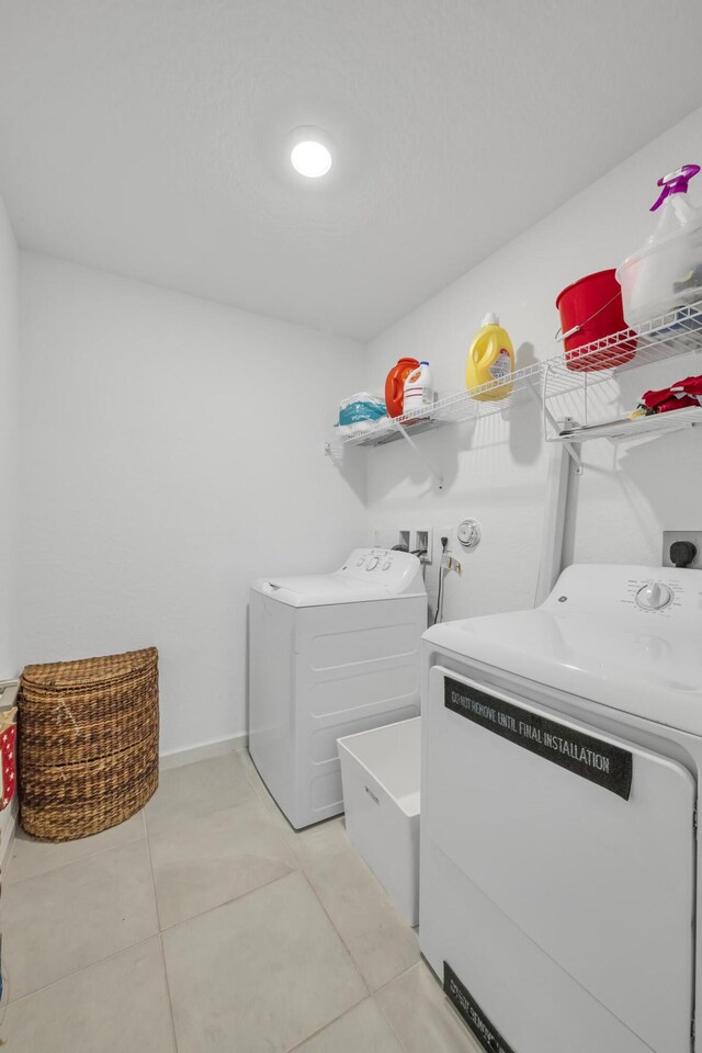 laundry room featuring light tile patterned floors and independent washer and dryer