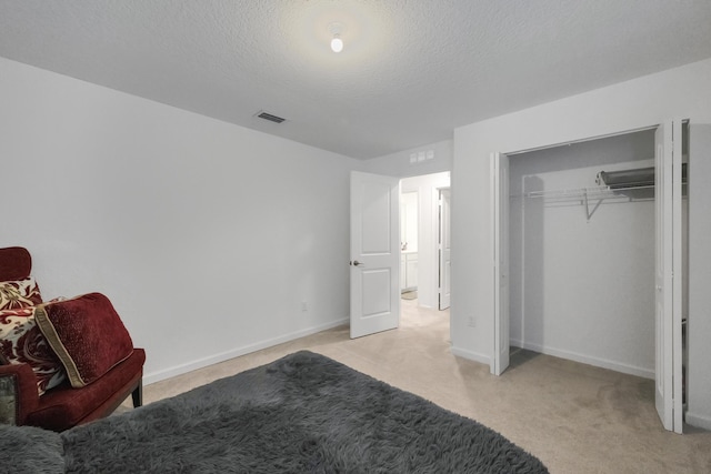 unfurnished bedroom featuring light carpet, a closet, and a textured ceiling