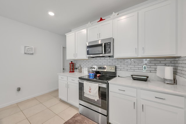 kitchen featuring tasteful backsplash, white cabinets, light tile patterned floors, and appliances with stainless steel finishes