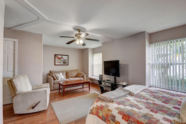 bedroom featuring hardwood / wood-style flooring, ceiling fan, and a textured ceiling