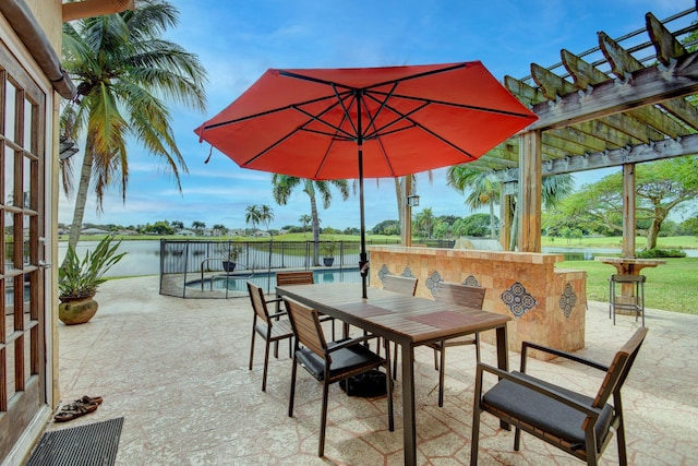 view of patio with a pergola and a water view