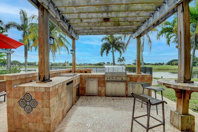 view of patio / terrace with a pergola, area for grilling, and a water view