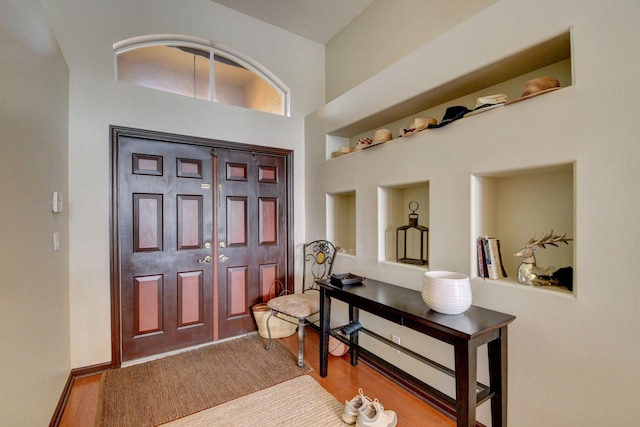 entryway with a towering ceiling and light hardwood / wood-style floors