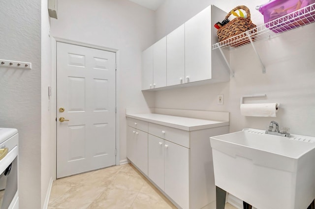 washroom with cabinets, washer / clothes dryer, and sink