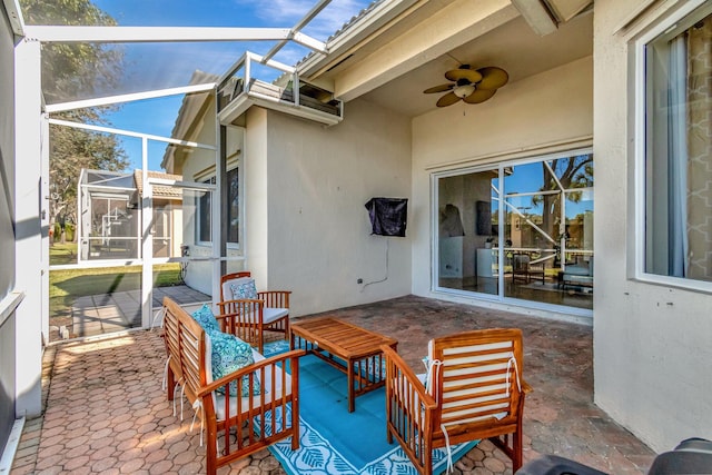 view of patio / terrace featuring glass enclosure, ceiling fan, and an outdoor living space