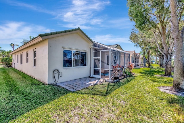 back of property with a lawn, a lanai, and a patio