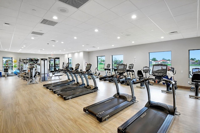 exercise room with a paneled ceiling and light hardwood / wood-style flooring